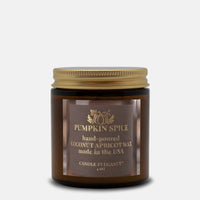 A 4 oz amber glass jar candle with a gold metal lid and a brown label reading 'Pumpkin Spice' by Candle Et Egance, set against a light gray background.