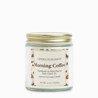 A 4 oz glass jar candle with a gold metal lid and a cream label reading 'Candle Elegance Morning Coffee' on a plain white background.