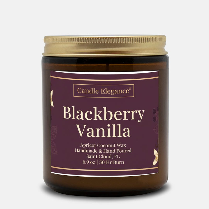 A jar of Candle Elegance Blackberry Vanilla scented wax candle, featuring a dark purple label with gold text and a gold metal lid, set against a light gray background.