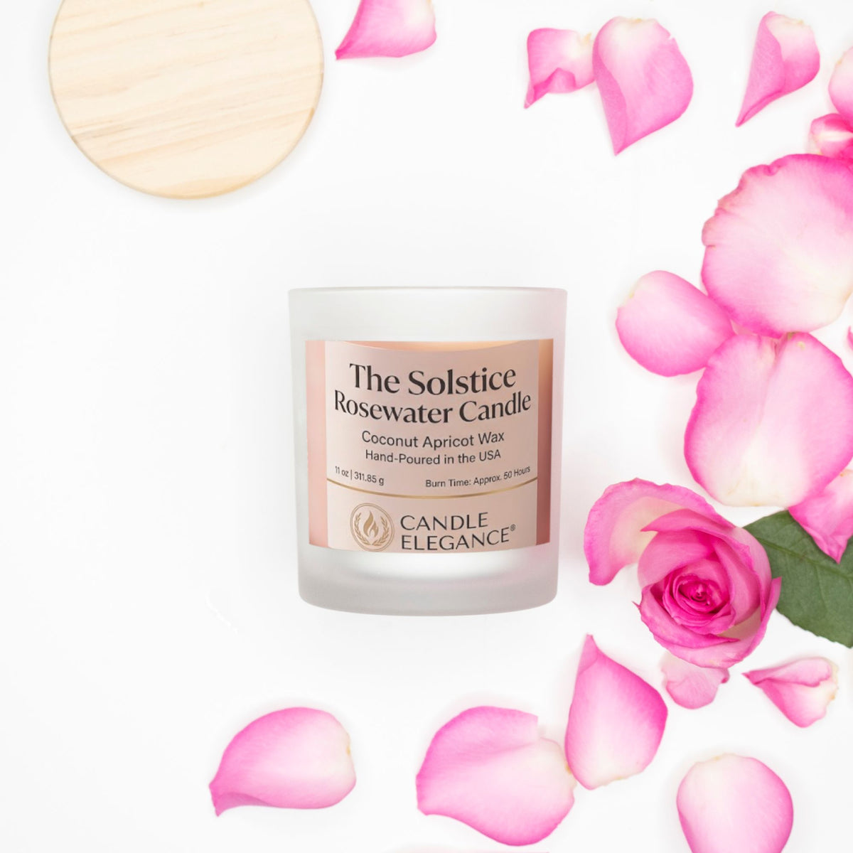 A frosted glass candle jar labeled 'The Solstice Rosewater Candle' by Candle Elegance, styled on a white background with scattered pink rose petals and a whole rose. A round wooden lid is partially visible in the top left corner.