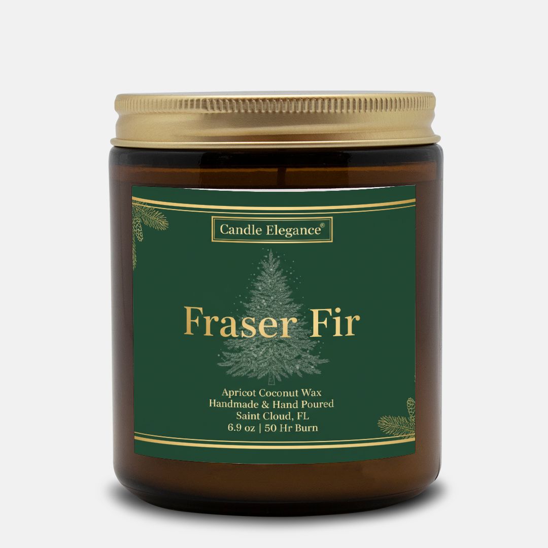 A Candle Elegance 'Fraser Fir' scented candle in an amber glass jar with a gold metal lid and a dark green label featuring a pine tree graphic.