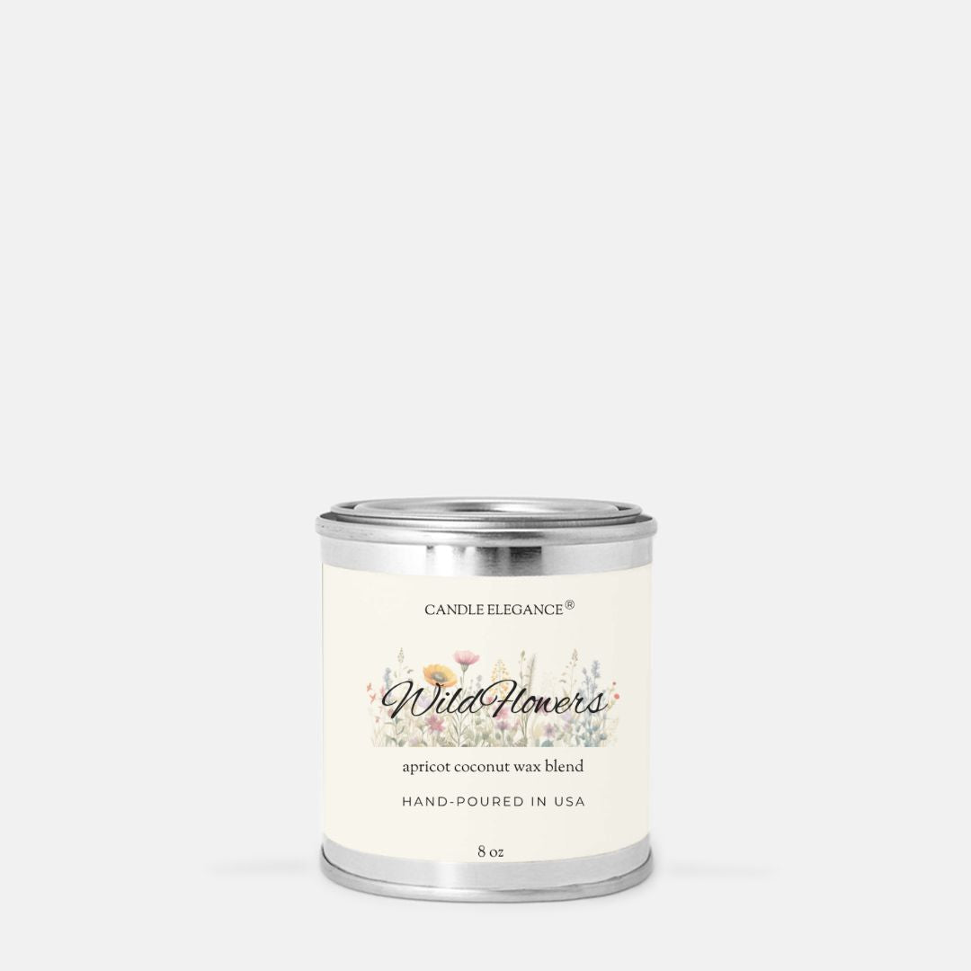 A 8 oz candle in a silver metal tin with a cream-colored label. The label features the brand name 'Candle Elegance' and the scent name 'Wild Flower' with a delicate floral illustration.