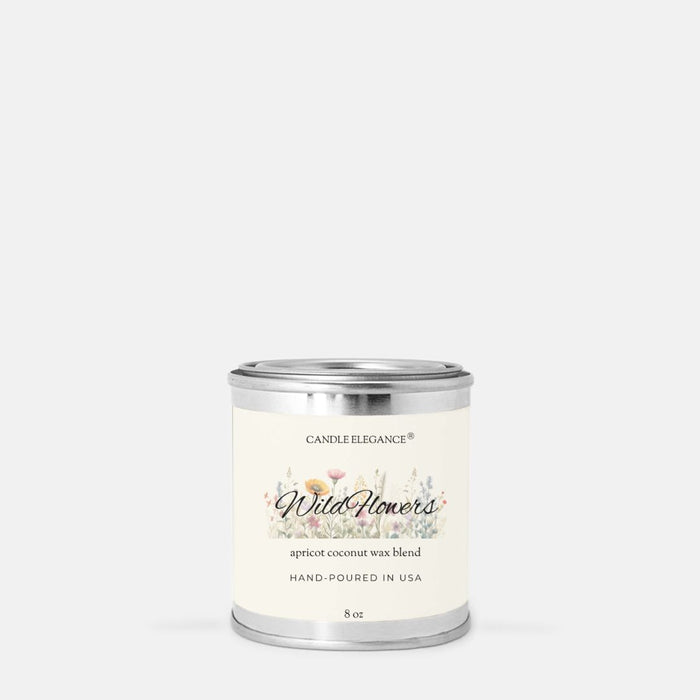 A 8 oz candle in a silver metal tin with a cream-colored label. The label features the brand name 'Candle Elegance' and the scent name 'Wild Flower' with a delicate floral illustration.