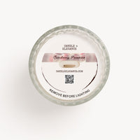 Top-down dust cover view of a Candle Elegance Cranberry Pearsson candle in a clear glass container with a white wax surface and a white paper label.