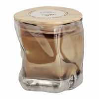 Clear glass jar with wooden lid containing irganic beeswax on a white background
