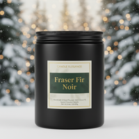 A black glass jar candle with a black lid and a cream label reading 'Candle Elegance' and 'Fraser Fir Noir,' set against a blurred festive holiday background with snow and warm lights.