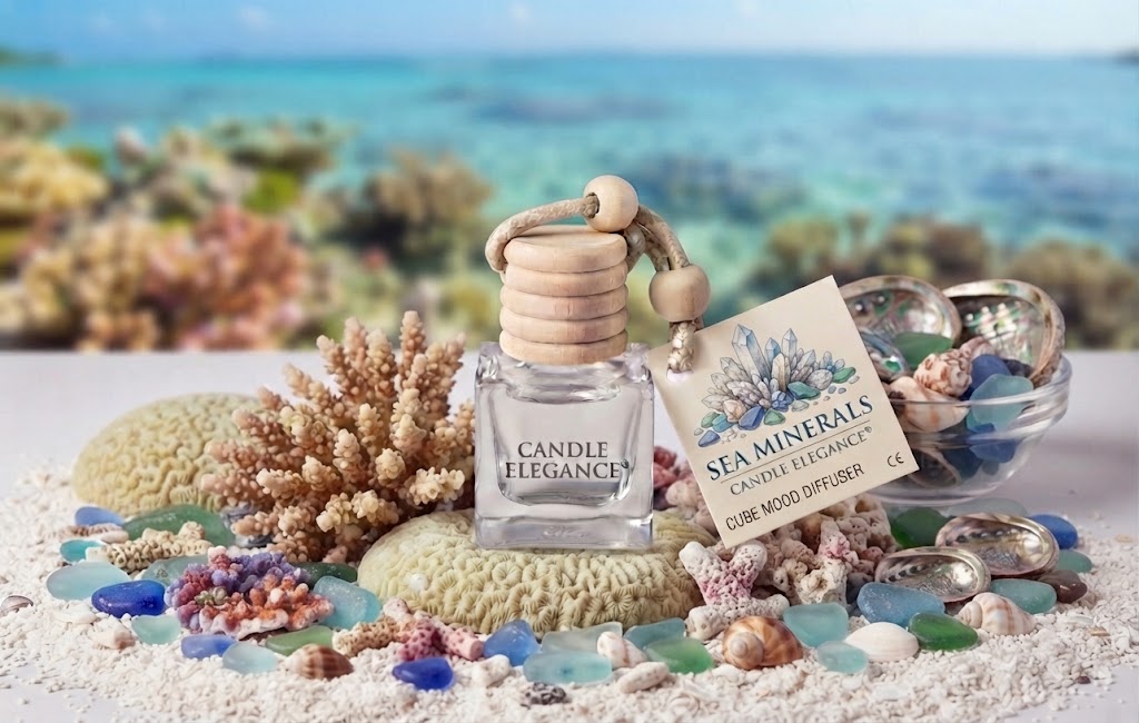 Sea Minerals Cube Mood Diffuser by Candle Elegance featuring a clear glass bottle with a wooden lid, surrounded by coral, seashells, and sea glass on a sandy background.
