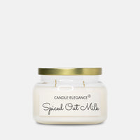 A Candle Elegance 'Spiced Oat Milk' scented candle in a clear glass jar with a gold metal lid and a white label, set against a solid light gray background.