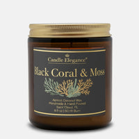 A jar candle from Candle Elegance labeled 'Black Coral & Moss' with apricot coconut wax, shown on a light gray background. The candle is in an amber glass jar with a gold lid and a black label featuring gold text and botanical illustrations.