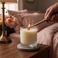 Bohemian Rose candle being lit on a walnut nightstand