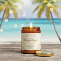 A lit amber glass jar candle labeled 'Coconut Soleil' by Candle Elegance sits on a wooden surface with its gold lid beside it, set against a blurred tropical beach scene with palm trees and turquoise water.