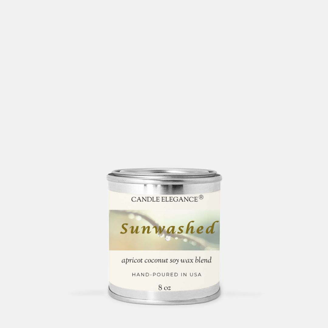 An 8 oz metal tin candle from Candle Elegance, named 'Sunwashed', with a cream and green label, set against a plain light gray background.