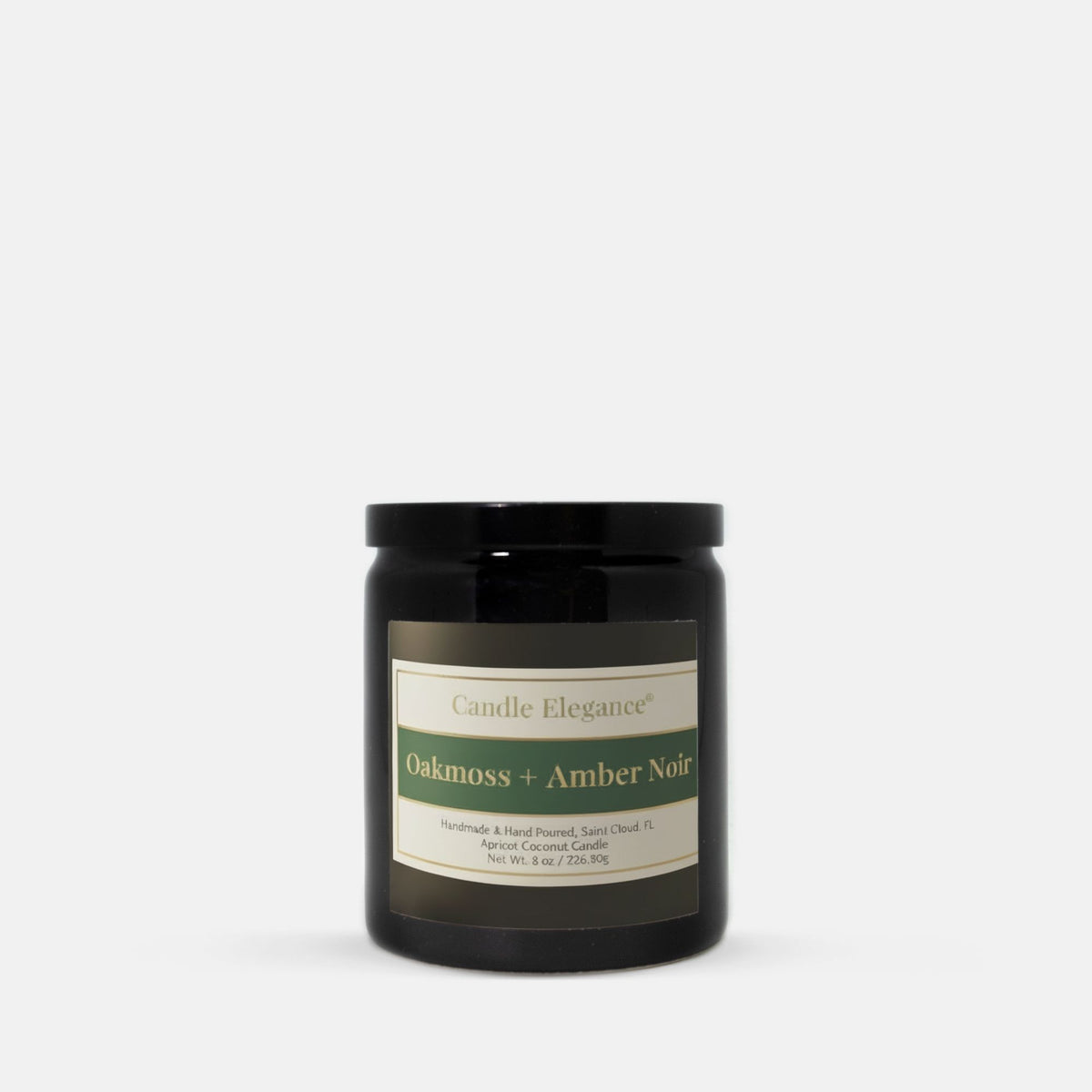 A black glass jar candle with a black lid and a cream label reading 'Candle Elegance' and 'Oakmoss + Amber Noir', photographed on a clean white background.