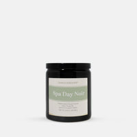 A black glass jar candle with a black lid and a cream label reading 'Spa Day Noir' by Candle Elegance, centered on a light gray background.