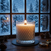 Fraser Fir candle beside a frosted cabin window overlooking a snowy forest at blue hour