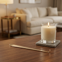 Gold wick dipper resting alongside a lit candle