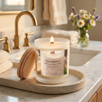 Lit Solstice Wildflower Honey candle on a luxe bath counter
