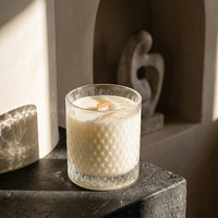 Unlit Bare Essence candle in a sculptural alcove with dramatic afternoon shadows