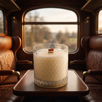 Unlit Bare Essence candle on a passenger train table